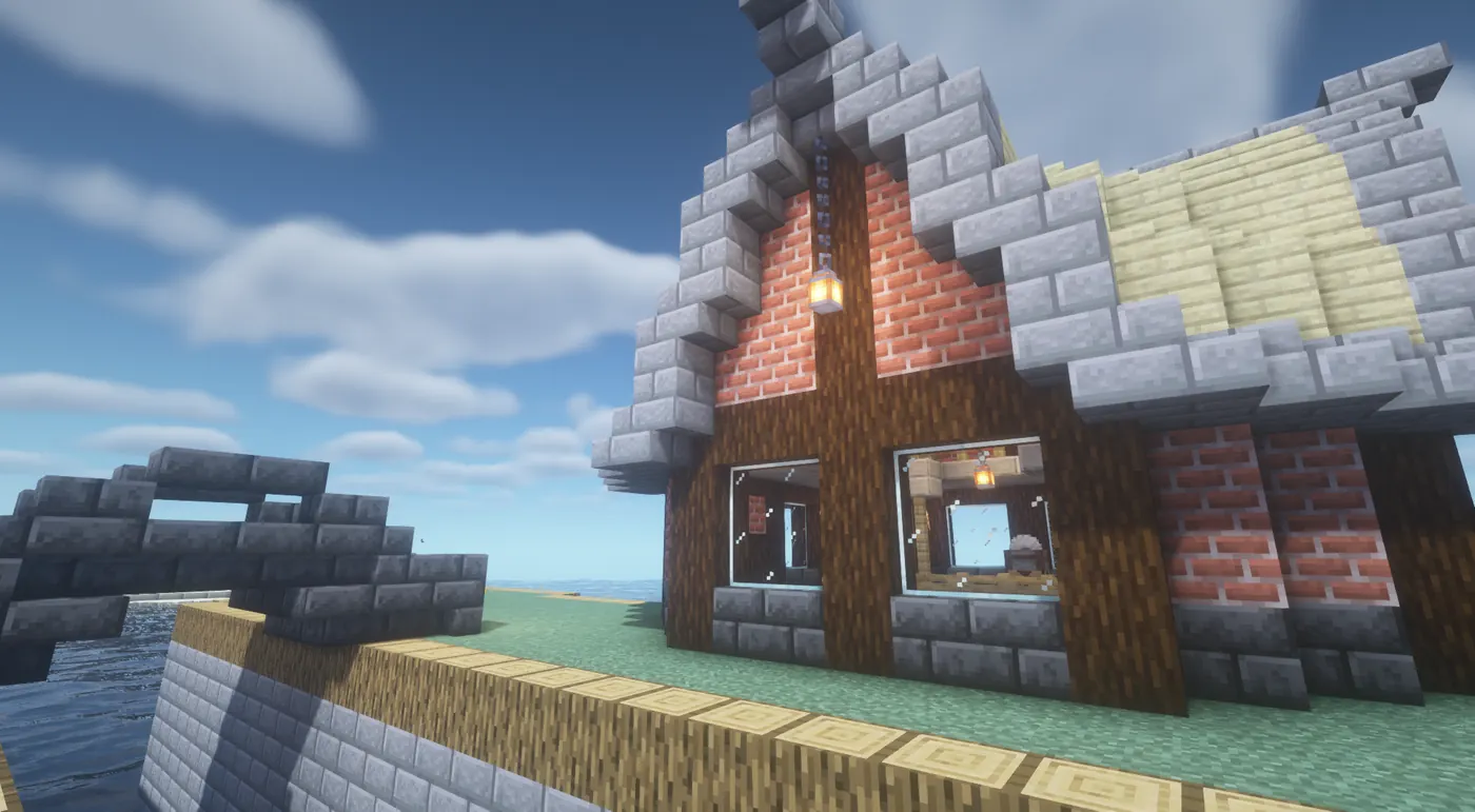 A Standard Survival build: a brick and timber house with a stone roof on the shore under a blue sky.